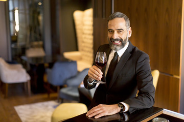 Senior handsome man drinking red wine