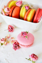 Obraz na płótnie Canvas Dessert: A Delicate Fresh Colorful French Macaroons In Pastel Colors Gift Box Flowers Roses On Light Textiles Background