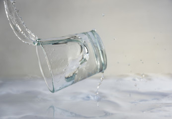 falling, flying or standing glass with a clear liquid intended for vodka and splash of liquid