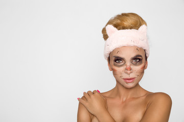 Beautiful woman with moisturizing leopard face mask. Mask with leopard, cat.