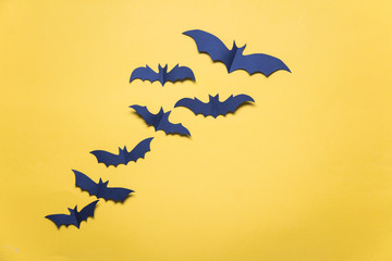 Halloween paper vampire bat decorations on an orange background.