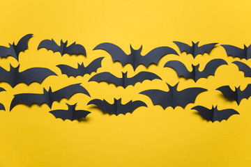 Fototapeta na wymiar Halloween paper vampire bat decorations on an orange background.