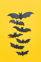 Halloween paper vampire bat decorations on an orange background.