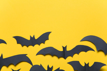 Halloween paper vampire bat decorations on an orange background.