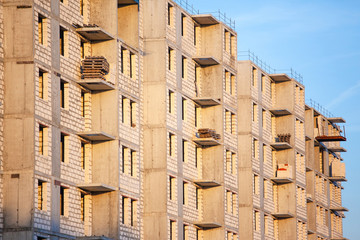 apartment house under construction in the rays of the setting sun