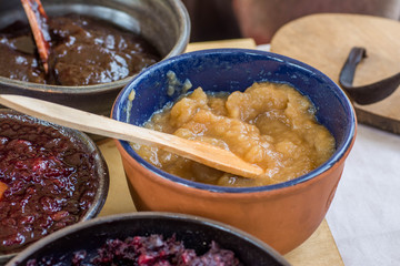Homemade jam in clay bowl with wooden spoon
