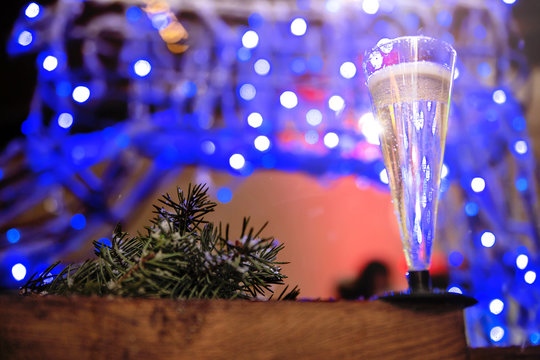 a glass of champagne on the background of Christmas lights