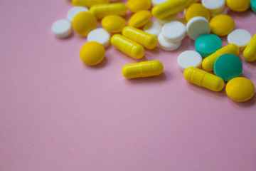closed up colorful antibiotic capsules pills tablets isolated on pink background, copy space