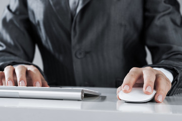 Closeup of businesswoman hand typing on keyboard with mouse on w