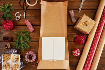 Christmas flat lay of unready hand crafted gift box on rustic wooden table with rolls of craft and...