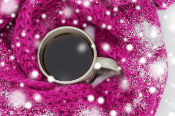 season, drinks, christmas and winter holidays concept - close up of tea or coffee mug and knitted woolen scarf in snow