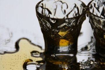 glass of honey whiskey and ice on white background