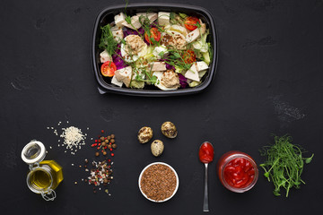 Salad with sauces and spices on black background