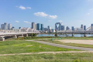 淀川右岸の河川敷から見た対岸の梅田ビル群と淀川と十三大橋