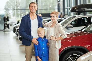 automobile sales centre. young family with child boy in car selling club