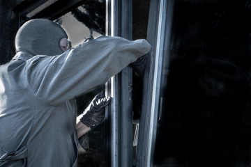 Einbrecher an gekipptem Fenster