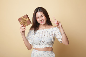 Asian woman show victory sign with a gift box.