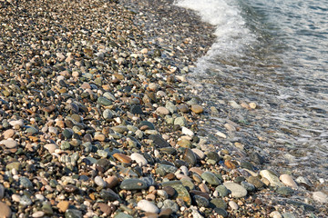Stone sea coast. Medium-sized pebbles washed with water.
