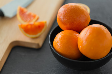 food, fruits and healthy eating concept - close up of fresh oranges in bowl