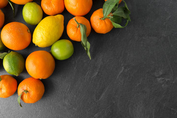 food, healthy eating and vegetarian concept - close up of citrus fruits on stone table
