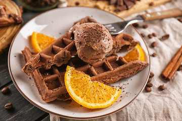 Delicious waffles with orange slices and ice cream on plate