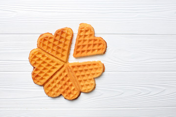Heart shaped waffles on white wooden background