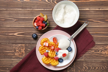 Heart shaped waffles with berries and ice cream on wooden background