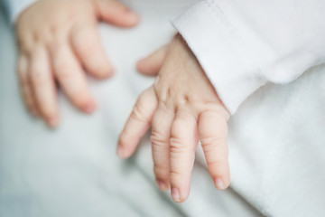 Obraz na płótnie Canvas baby's hands close up. infant sleeping on dad's shoulder