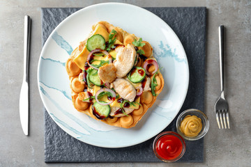 Delicious bubble waffle with meat, cheese and sauces on slate plate