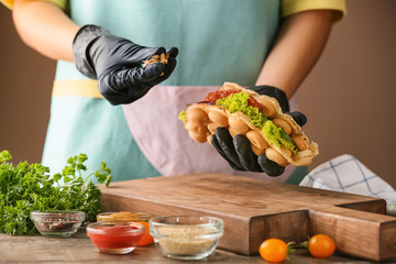 Woman preparing delicious bubble waffle at table
