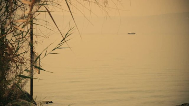 Sea of Galilee in the early morning, ripples on the water and boat. Israel, cca. 2015