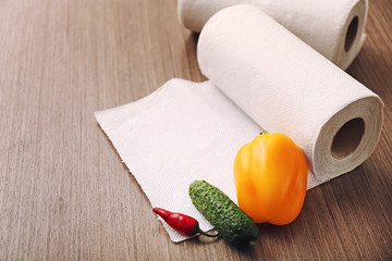Rolls of paper towels with vegetables on kitchen table