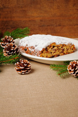 traditional Christmas Stollen on plate, wooden background