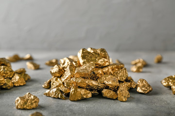 Gold nuggets on grey table