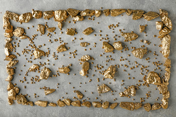 Gold nuggets on grey background