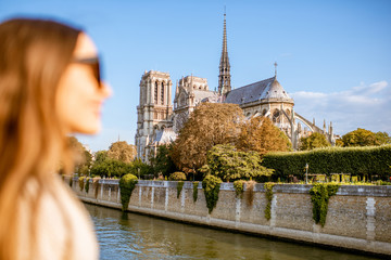 Cityscape view on the famous Notre-Dame cathedral on Seine river with woman face on the foreground...