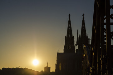 Naklejka premium Sun Setting behind a Cathedral by a Bridge