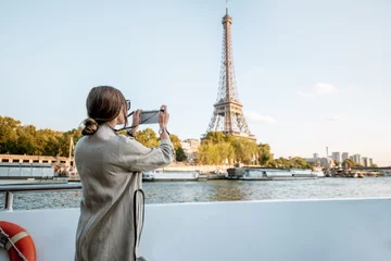 Store enrouleur tamisant Paris Young woman enjoying beautiful landscape view on the riverside with Eiffel tower from the boat during the sunset in Paris