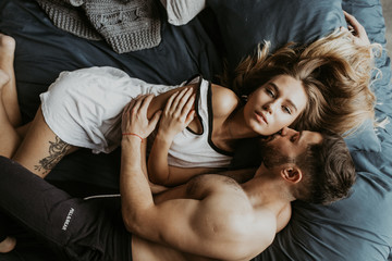 
Beautiful loving couple kissing in bed - obrazy, fototapety, plakaty