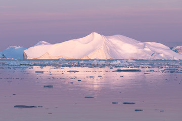 Magical and almost surreal alpen glow lighting up glacier in purple light during midnight sun....