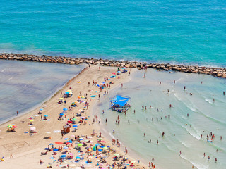 Beautiful beach and sunbathers and the mediterranean sea in Alicante. Spain.