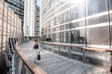 Business woman walking outdoors at the financial district with modern buildings on the background in Paris