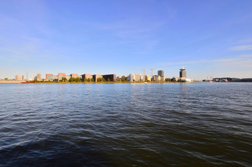 Naklejka premium Rzeka Ij i budynki na brzegu w pogodny dzień.