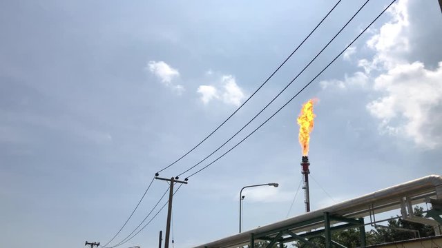 A gas flare at an oil refinery. Flare tower in Refinery plant during burn out gas from refinery process