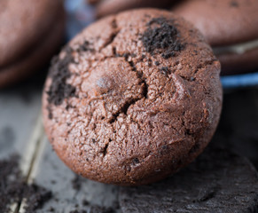 Chocolate cookies and brownie biscuit on black wood table.