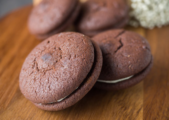 Chocolate cookies and brownie biscuit on black wood table.
