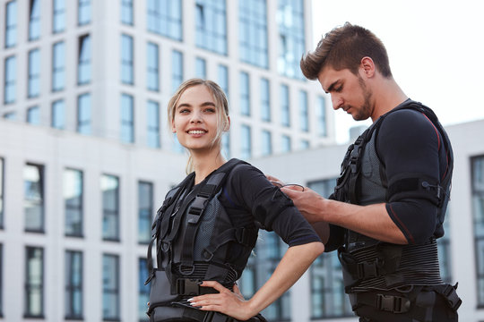 awesome smiling blond woman is going to work out with ems costume. close up photo. grown ups are good at sport