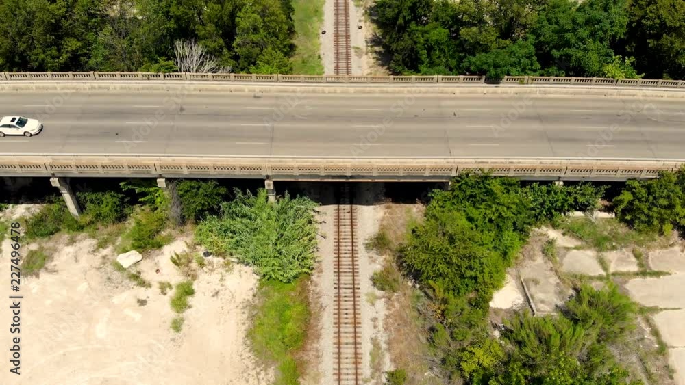 Poster a heighted drone shot, with forward dolly motion, capturing railway tracks with trees on the sides a