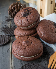 Chocolate cookies and brownie biscuit on black wood table.