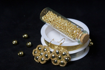 Bead jewelery. DIY jewelry. Necessary accessories. Beads and ready-made earrings. Tools and fixtures. On a black background.